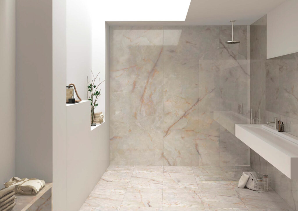 Sala de baño revestida y pavimentada en mármol porcelánico de tono salmón.