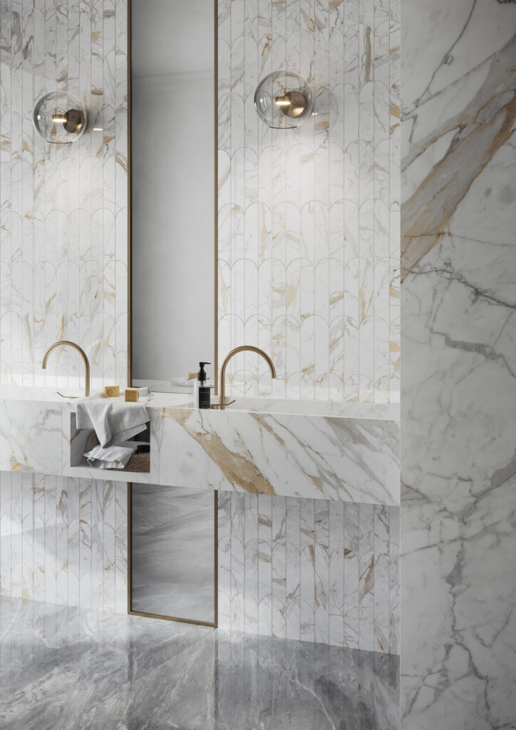 Sala de baño revestida en mármol lujoso con grifería dorada y detalles en oro.