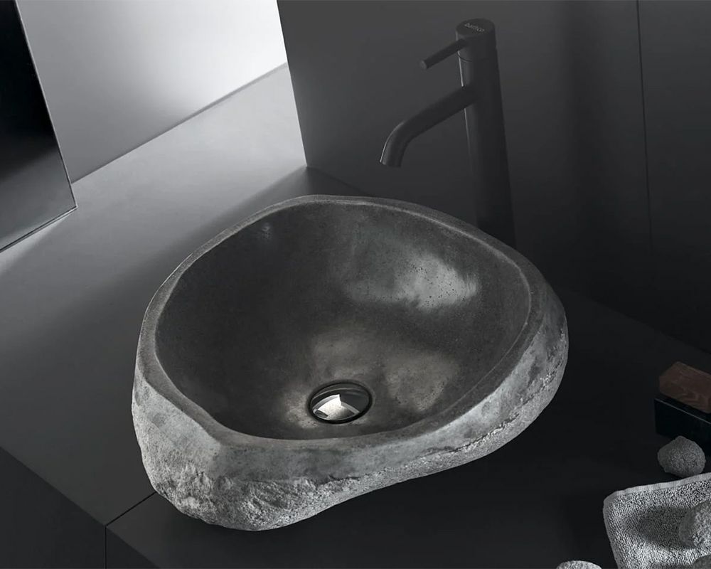 Lavabo de piedra sobre encimera con grifo monomando en negro